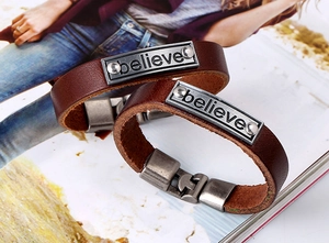 Vue détaillée des bracelets en cuir marron vintage avec plaque métallique gravée believe
