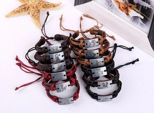 Detail of woven leather zodiac bracelets with metal plaques and adjustable cord design
