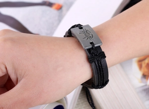 Gros plan du bracelet en cuir tressé noir avec plaque en métal antique du signe Cancer