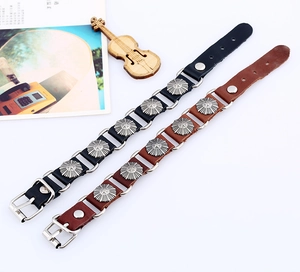 Dettaglio di bracciali in pelle regolabili nero e marrone con borchie sole vintage