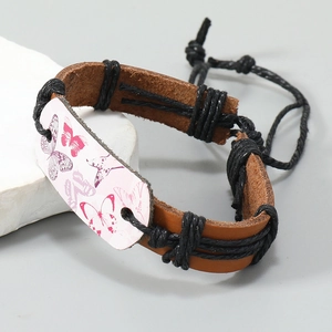 Bracelet artisanal en cuir marron avec motif papillon et cordon tressé élégant