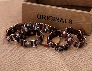 Macro view of vintage brown leather bracelets with skull and iris flower metal charms