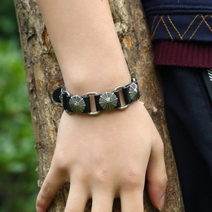 Dettaglio del bracciale in pelle punk con borchie a stella e maglie in metallo
