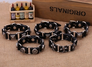 Close-up of five black leather punk bracelets with silver metal cross and rivet charms