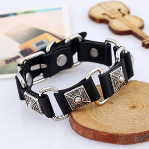 Punk style wide black leather bracelet with silver relief metal accents and snap closure