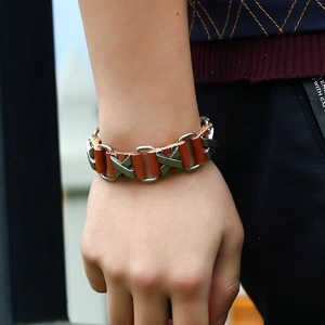 Detail of adjustable brown leather bracelet with silver metal X studs and links