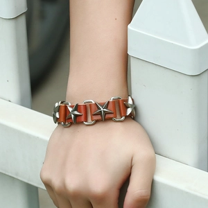 Punk brown leather bracelet with silver star metal studs shown on a male wrist