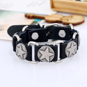 Gros plan sur bracelet punk en cuir noir avec embossage étoile et anneaux métalliques