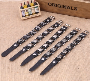 Five styles of black leather bracelets with metallic charms on beige woven background