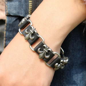 Detail of vintage gothic leather bracelet featuring silver fleur-de-lis metal charms