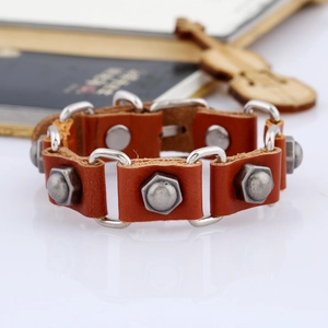 Détail du bracelet en cuir marron avec des maillons en métal et rivets industriels