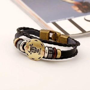 Détail d'un bracelet multicouche en cuir tressé avec plaque Taureau en laiton vieilli