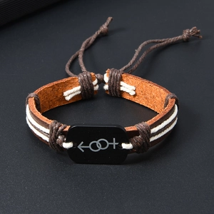 Close-up of woven leather bracelet featuring a black plaque with gender symbols