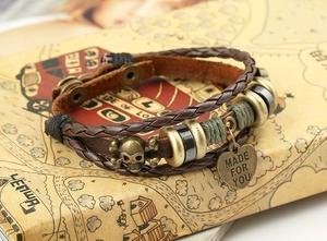 Detail of punk braided leather bracelet with skull charm and Made For You heart tag