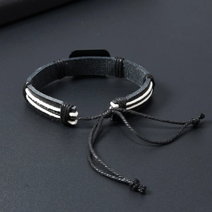 Detail view of a vintage hand-woven black leather bracelet with white contrast stitching