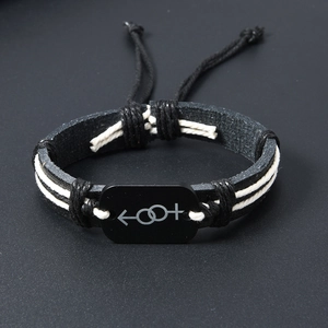 Detail of woven leather bracelet featuring black gender symbol charms and adjustable cord