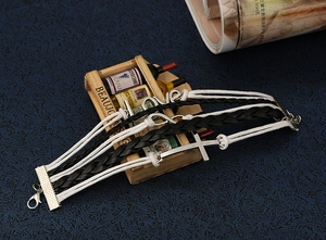 Close-up of multilayer woven leather bracelet with cross, infinity, and love charms