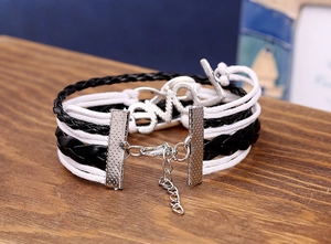 Detail of multi-layer woven leather bracelet featuring a silver LOVE letter charm