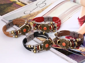 Detailed shot of multi-layer leather bracelets with sunflower alloy charms on a magazine