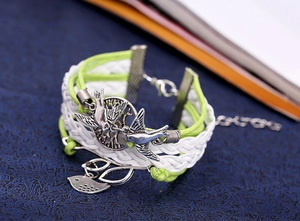 Vue détaillée du bracelet multicouche tissé à la main avec breloques arbre et oiseau