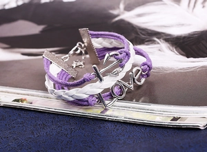 Detail of purple and white leather bracelet with silver anchor and LOVE charms