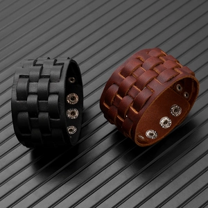 Detail view of black and brown multi-layer leather bracelets with silver metal snaps