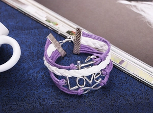 Detail of multi-layer leather bracelet with silver Love charm and anchor hook