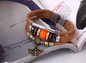 Detail of bohemian leather bracelet featuring butterfly charm and multi-layered beads