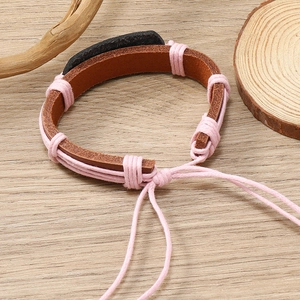 Detail of hand-woven leather bracelet with pink cord and adjustable drawstring closure