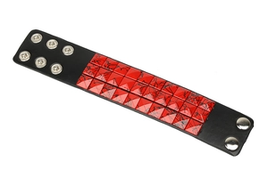 Detail view of punk wide leather bracelet with red pyramid studs and adjustable snaps