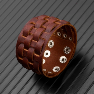 Detail of multi-layer brown woven leather bracelet with adjustable silver metal snaps
