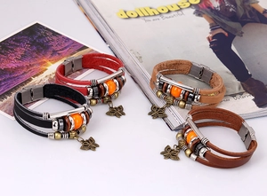 Detail of bohemian multilayer leather bracelets with wood beads and butterfly charms