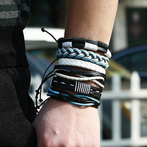 Handgefertigtes Lederarmband-Set in Schwarz und Blau am Handgelenk einer Person
