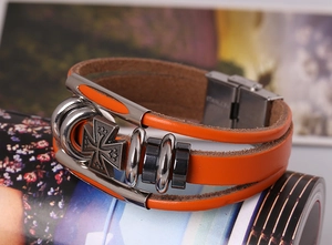 Macro detail of multi-layer orange leather cross bracelet with stainless steel buckle