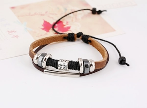 Detail view of multilayer vintage leather bracelet with metal beads and braided ropes
