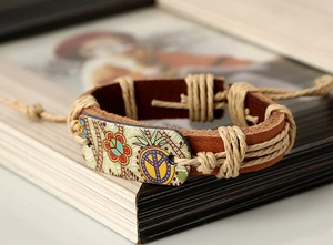 Vue rapprochée du bracelet rétro en cuir tressé avec signe de paix et détails en chanvre
