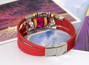 Détail du bracelet multicouche en cuir rouge avec perles et fermoir magnétique