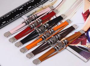 Detail of six multilayer leather bracelets featuring vintage iron cross metal charms