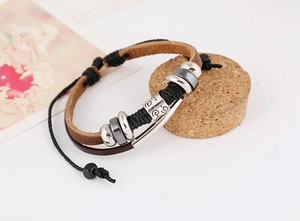 Detail of multilayer leather bracelet with silver metal beads and carved spiral tube