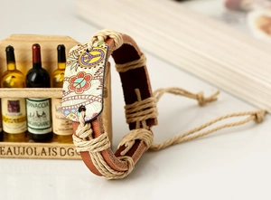 Détail d'un bracelet en cuir tressé avec symbole de paix coloré et motif floral