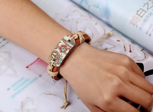 Détail d'un bracelet en cuir tressé bohème avec signe de paix et corde de chanvre