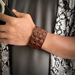 Detail of multi-layer brown braided leather bracelet worn on wrist for men