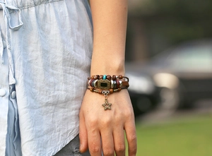 Vue détaillée d'un bracelet multicouche en cuir avec perles de bois et étoile