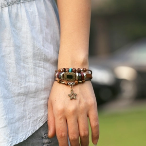 Bracelet multicouche en cuir avec perles et pendentif étoile sur le poignet d'un modèle