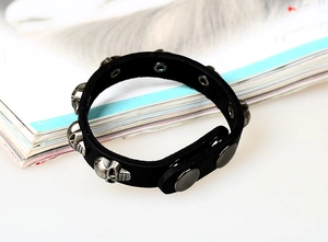 Detail view of black leather punk bracelet with silver skull studs and snap buttons
