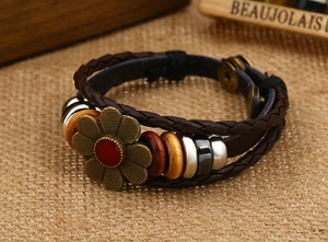 Dettaglio del bracciale in pelle intrecciata multistrato con girasole in bronzo