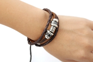 Dettaglio ravvicinato del bracciale in pelle intrecciata a strati con perline in lega argento
