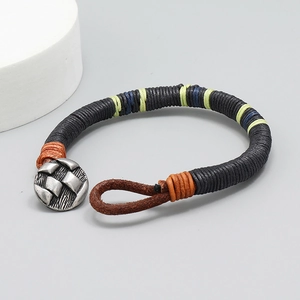 Détail du bracelet en cuir tissé à la main avec motif ethnique et bouton argenté vintage