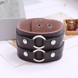 Detail view of wide punk leather bracelet with double silver rings and metallic rivets