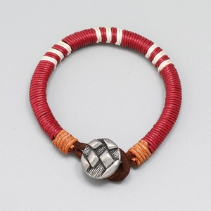Détail d'un bracelet en fil de cire tissé avec boucle en cuir et fermoir bouton métallique
